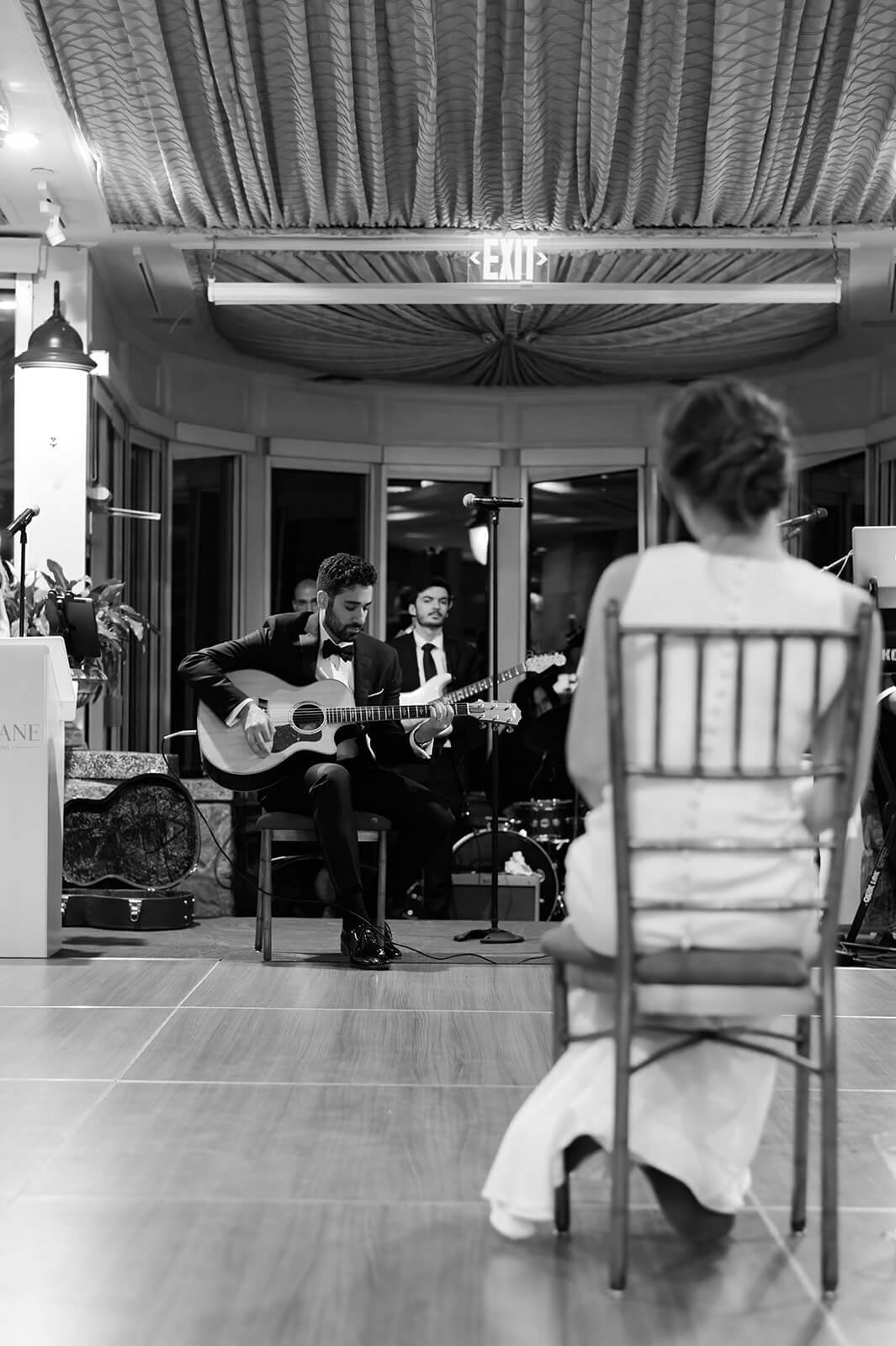 Groom singing a song to his bride on a acoustic guitar