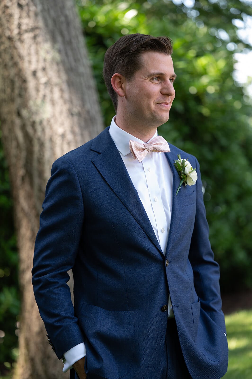 Groom in a blue suit with blush bowtie for his Long Island wedding
