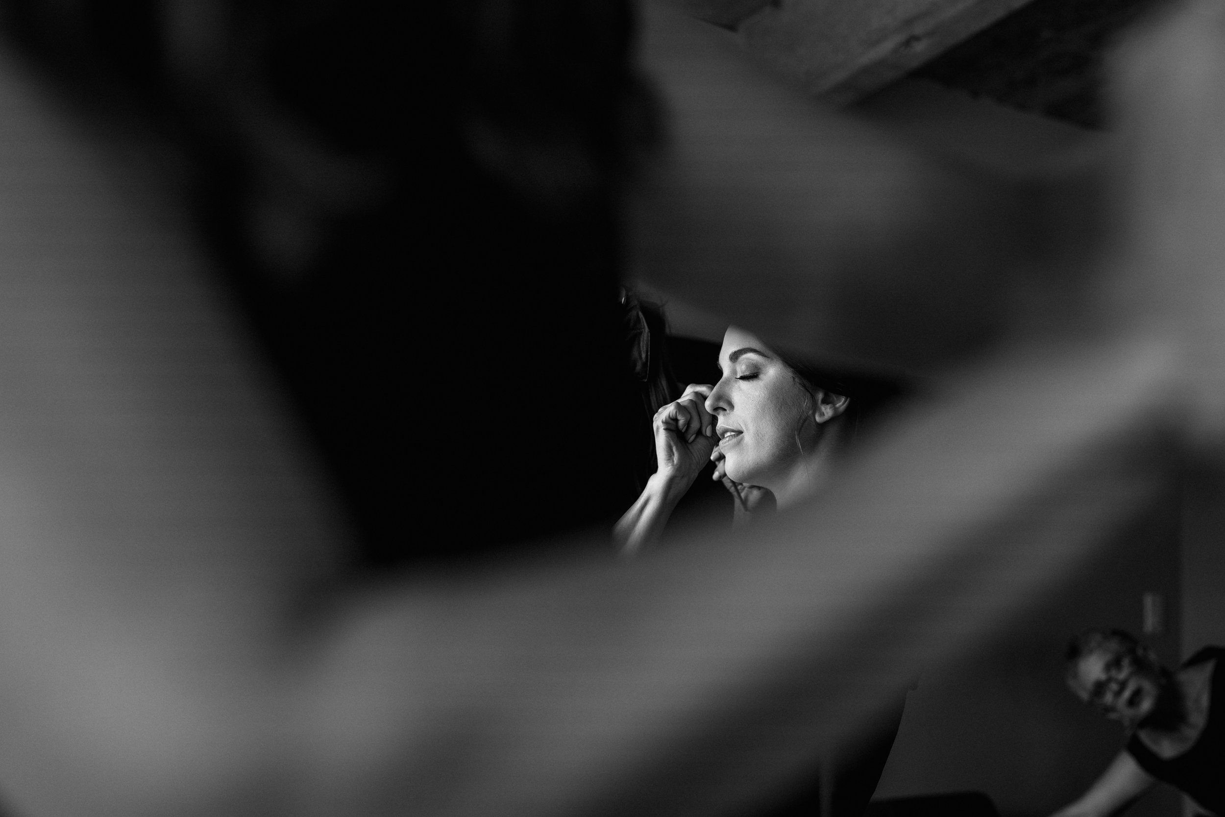Black and white image of The Luminous Bride doing makeup