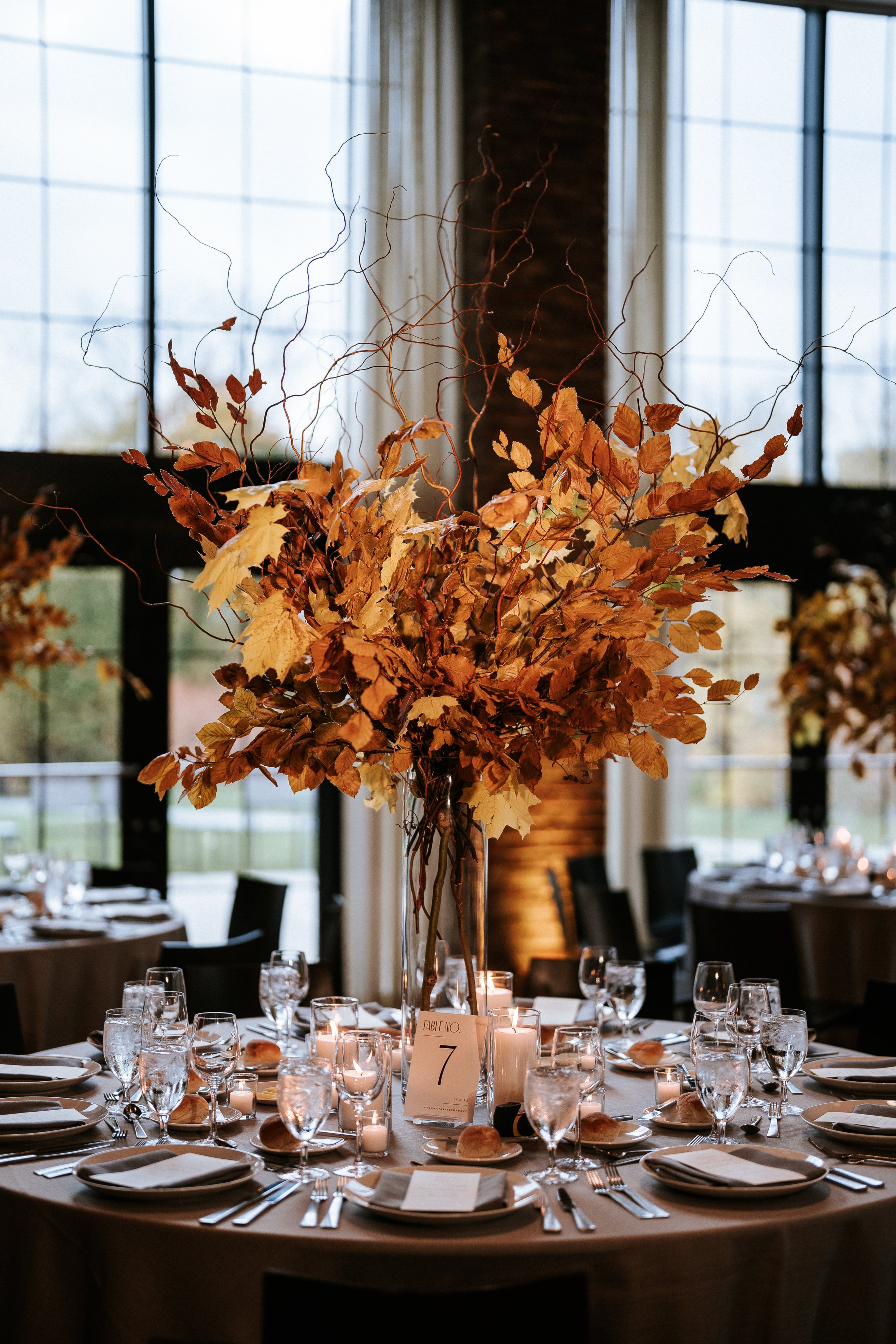 Fall inspired wedding reception centerpiece filled with fall leaves