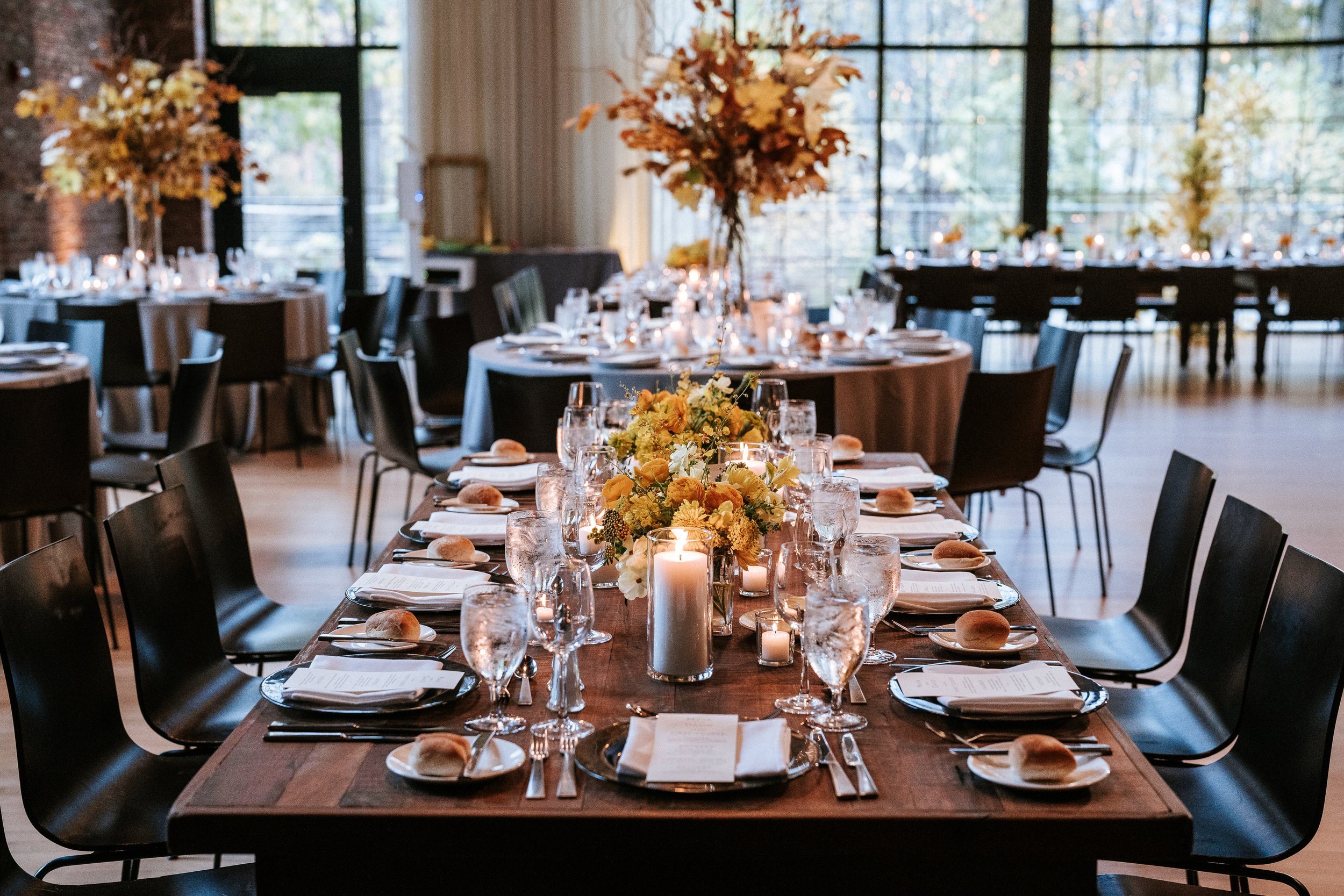 Fall inspired wedding reception centerpiece filled with fall leaves