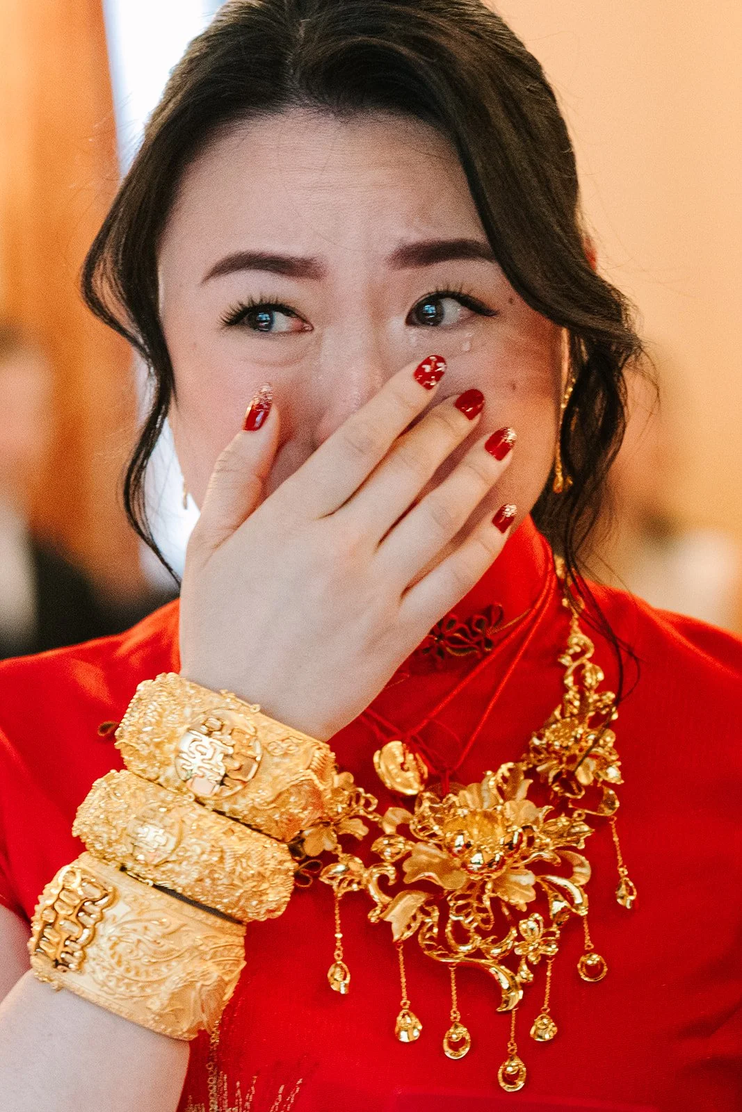 Emotional bride wiping tears during the private home wedding celebration.