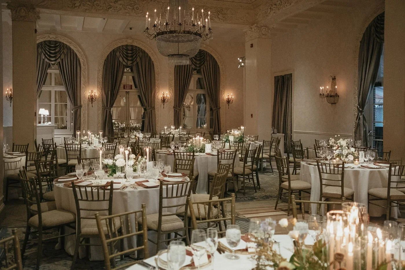 Elegant winter reception table decorated with candles, greenery, and gold accents, complementing the overall winter wedding fashion aesthetic of the celebration.