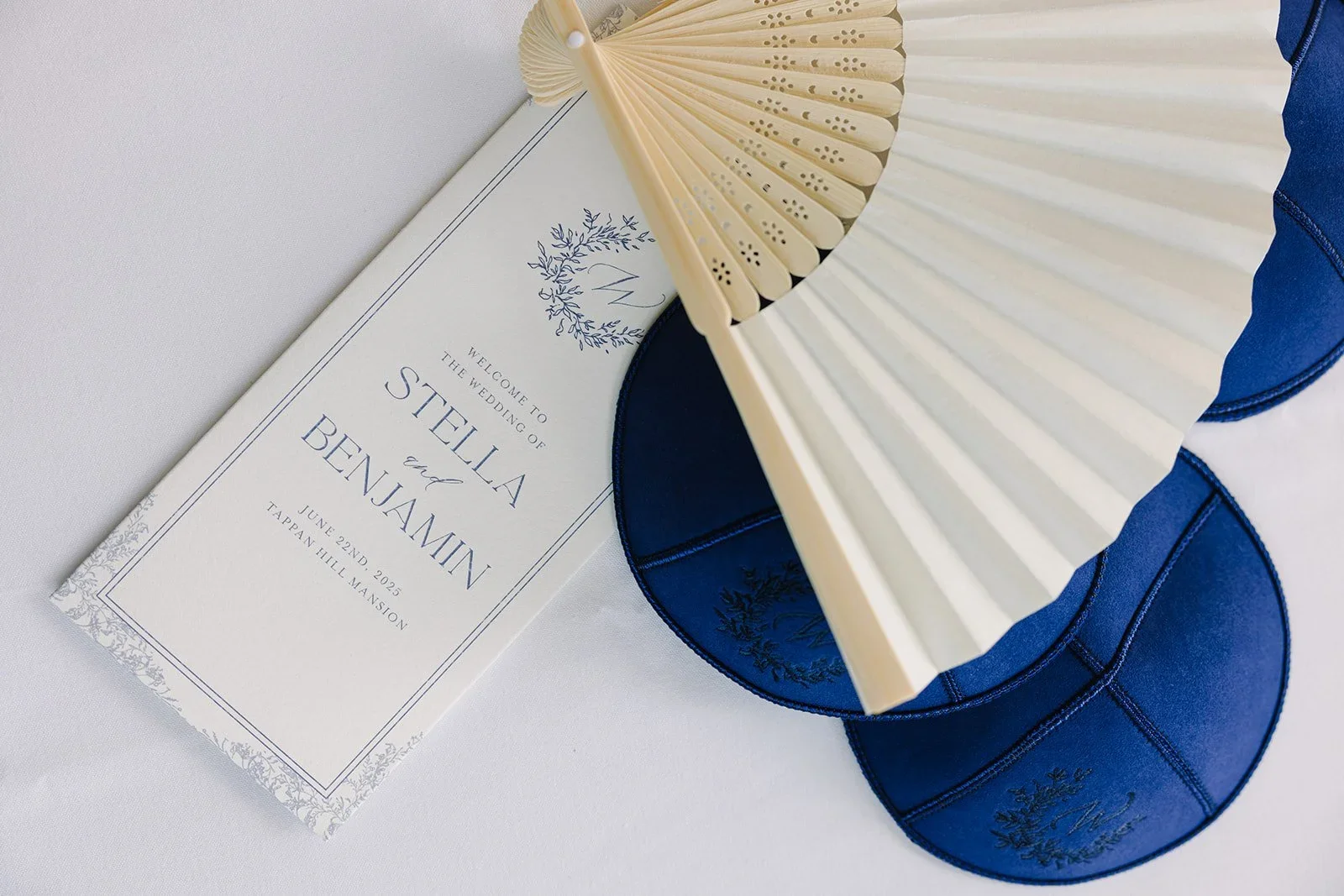 Flat lay of fans, Jewish head coverings, and wedding stationery details for a jewish wedding in New York