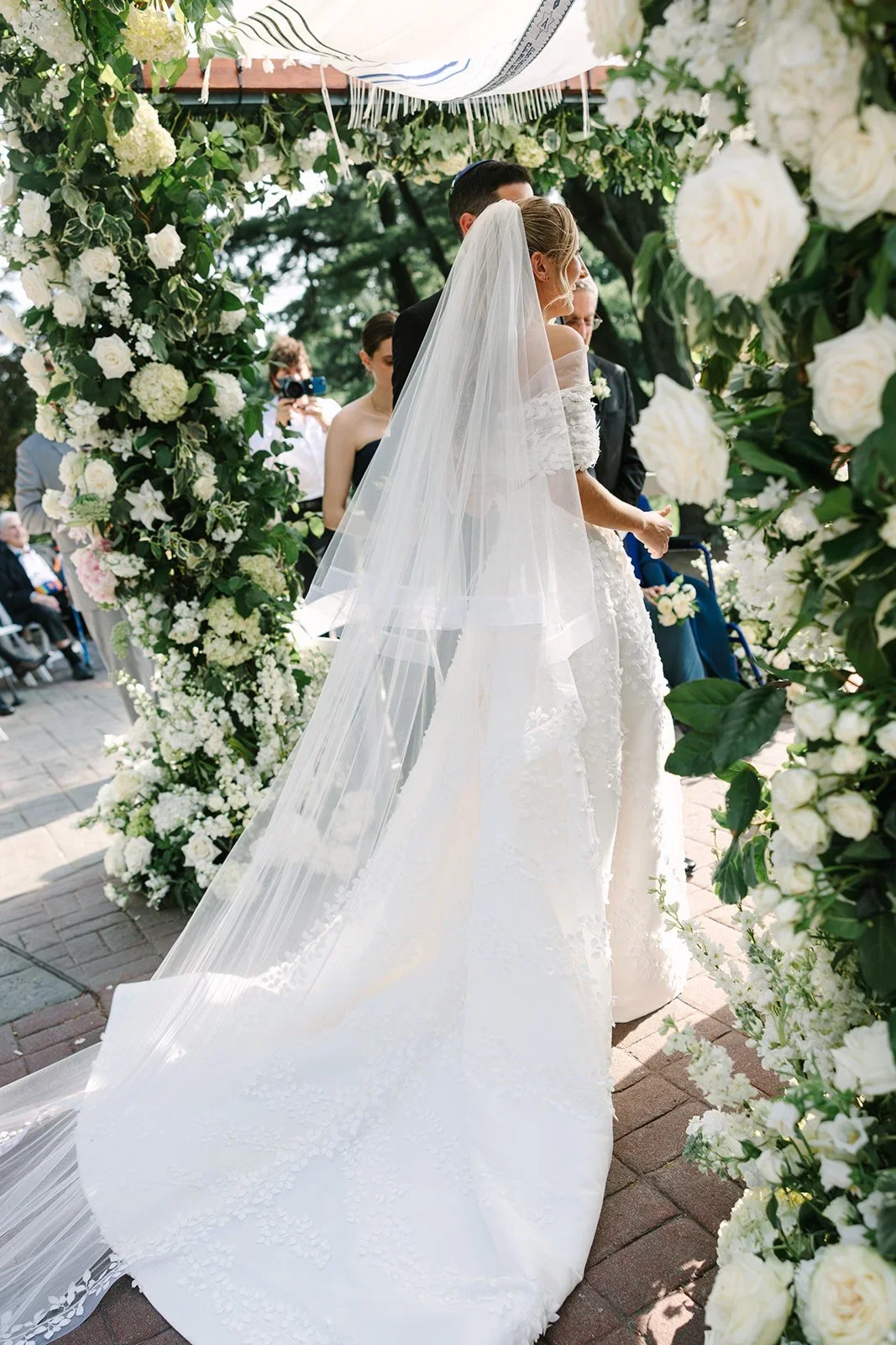 Bride standing beneath the chuppah surrounded by florals during a jewish wedding in New York