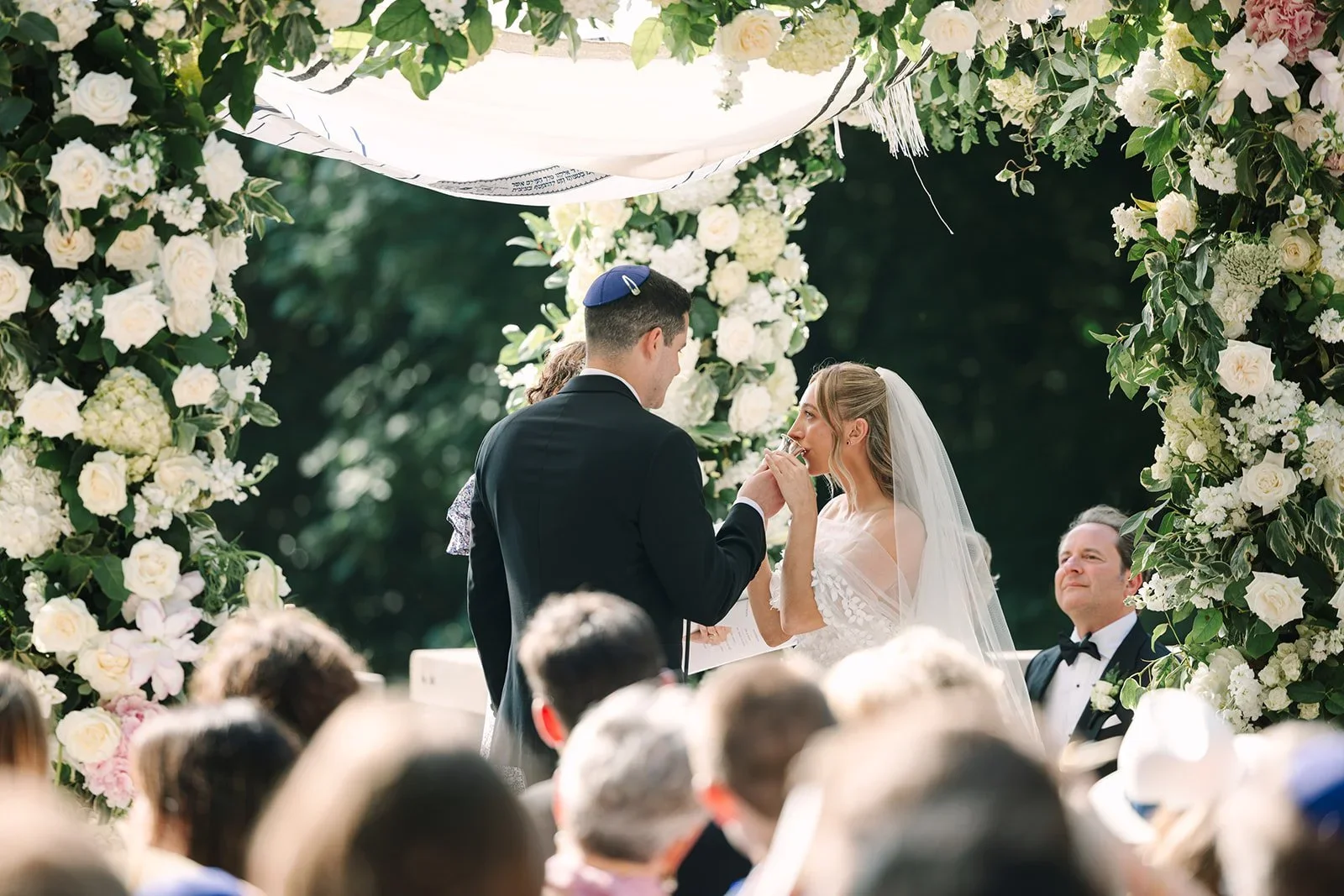 Bride drinking from a traditional Jewish ceremonial cup during the wedding ceremony