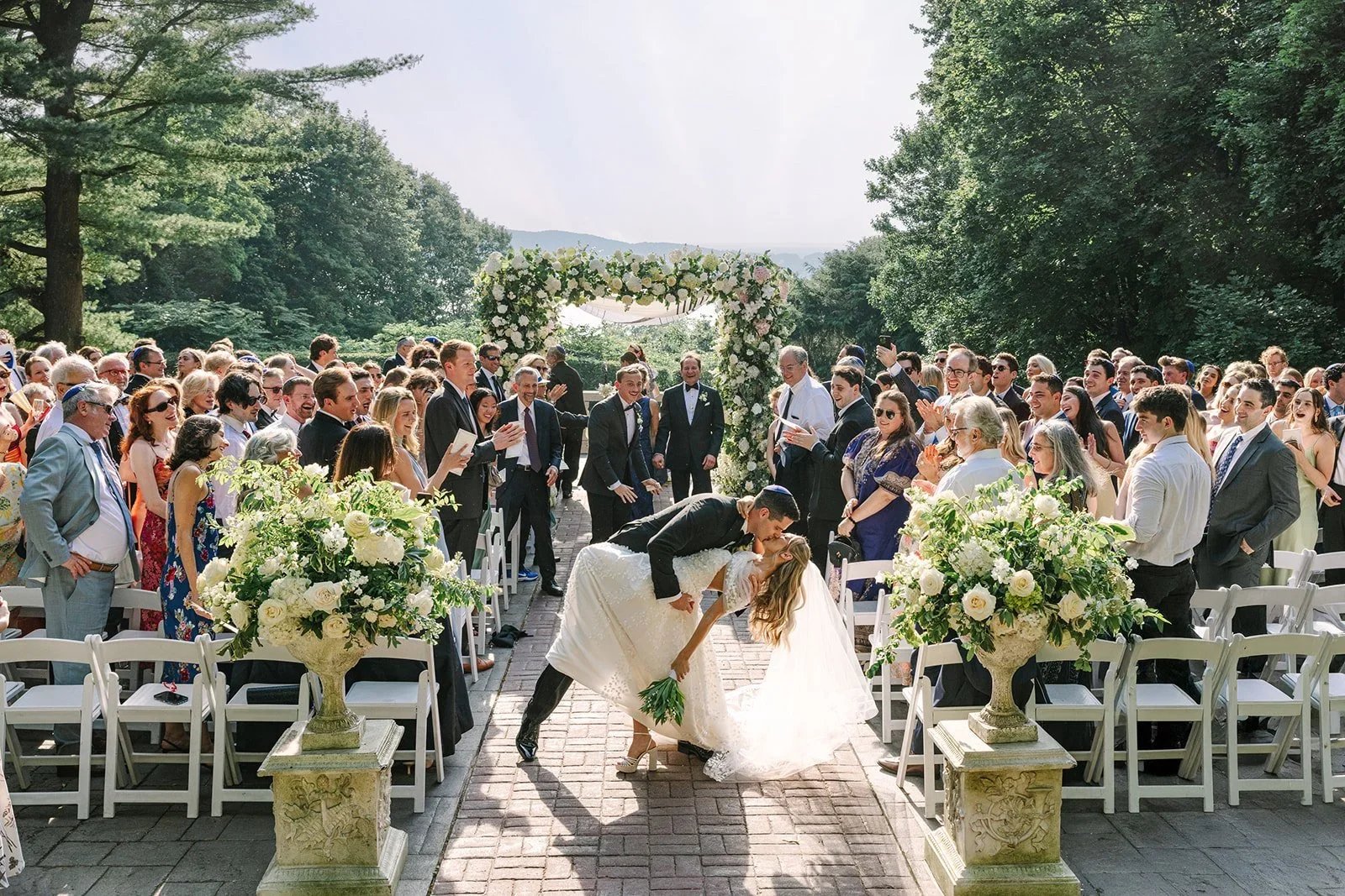 Bride and groom kissing and walking back down the aisle at the conclusion of a jewish wedding in New York