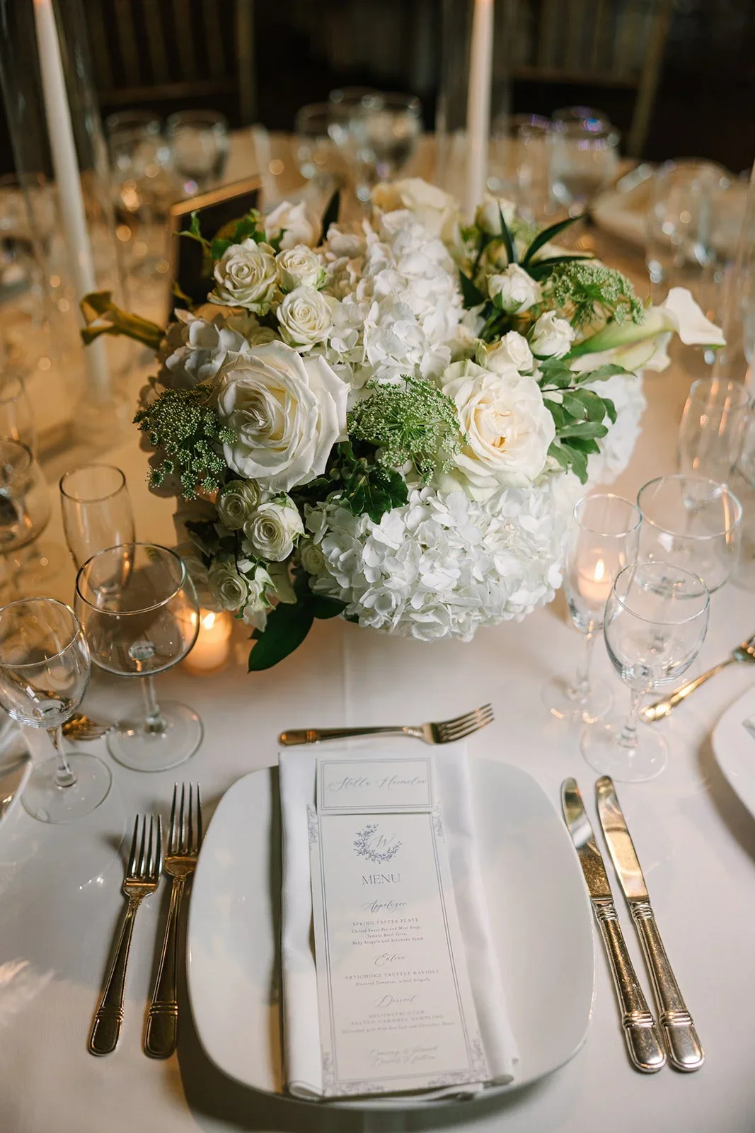 Elegant table details with florals, menus, and candlelight at a jewish wedding in New York