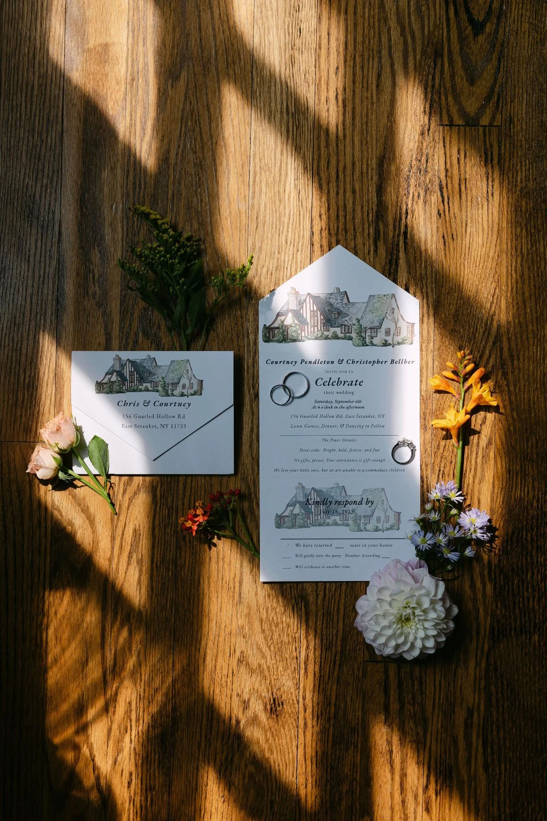 Custom illustrated wedding invitations with floral details for an outdoor wedding in New York, photographed on wood floor with natural light