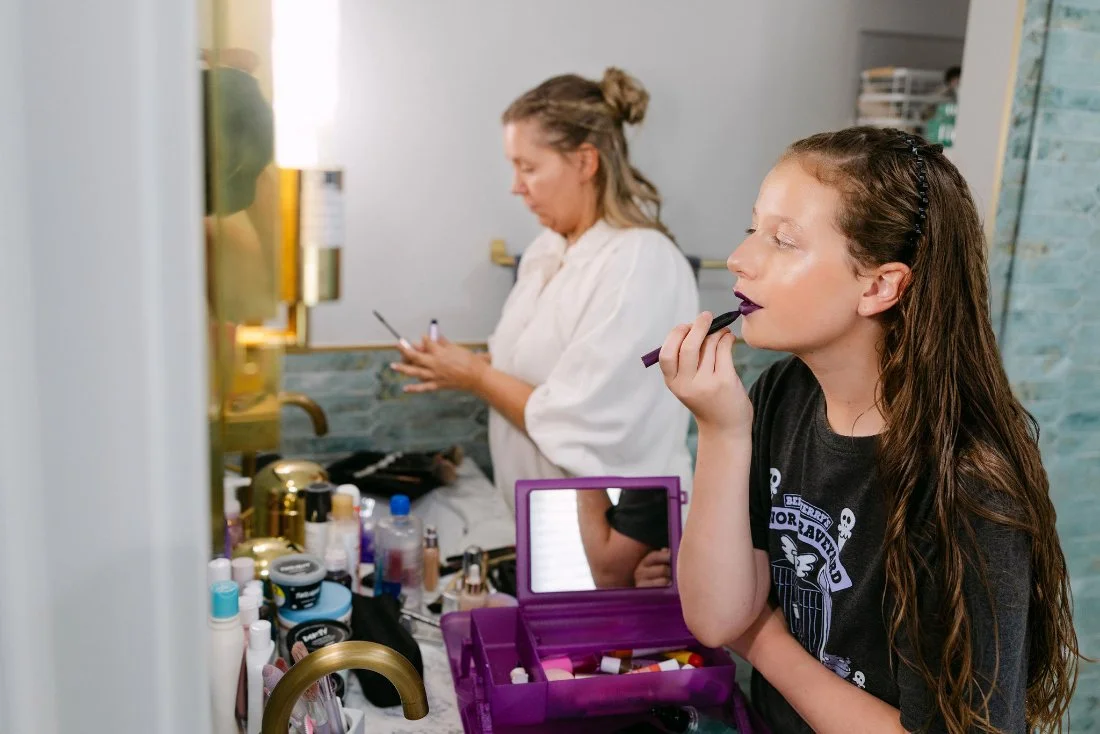 Mother and daughter applying makeup together before an outdoor wedding in New York