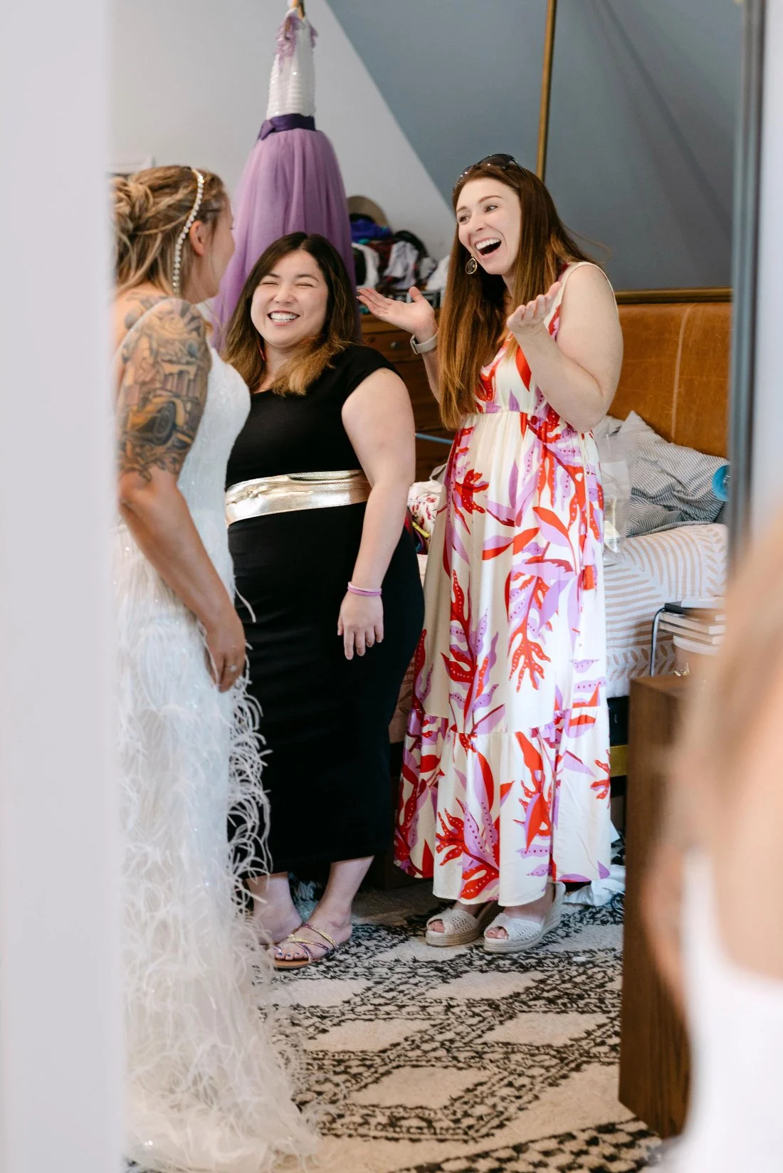 Bride laughing with friends in her getting ready suite on the morning of her outdoor wedding in New York