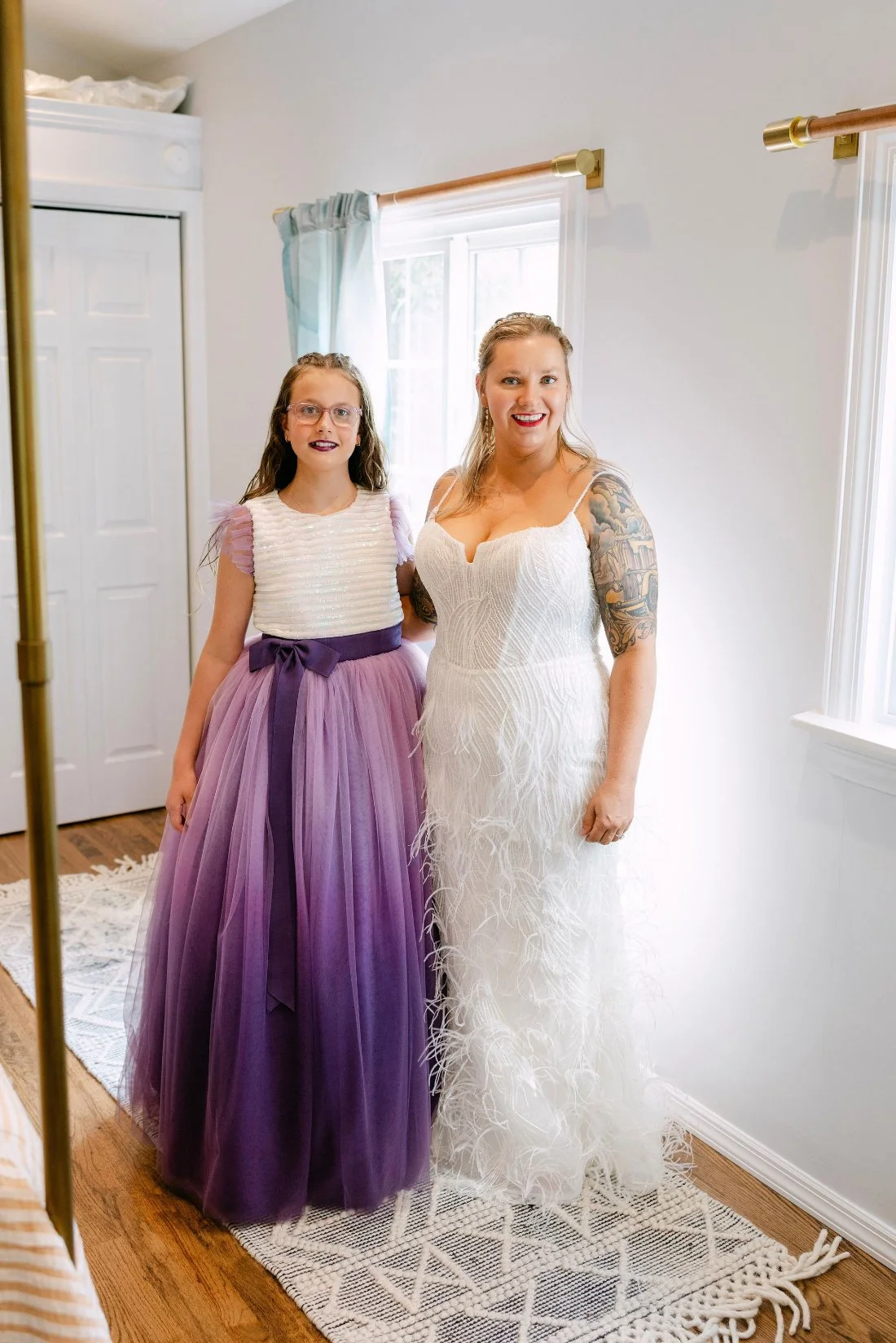 Bride posing with daughter before outdoor wedding in New York, both wearing formal wedding attire