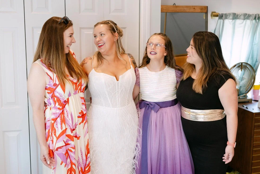 Bride with her daughter and friends smiling together before outdoor wedding in New York