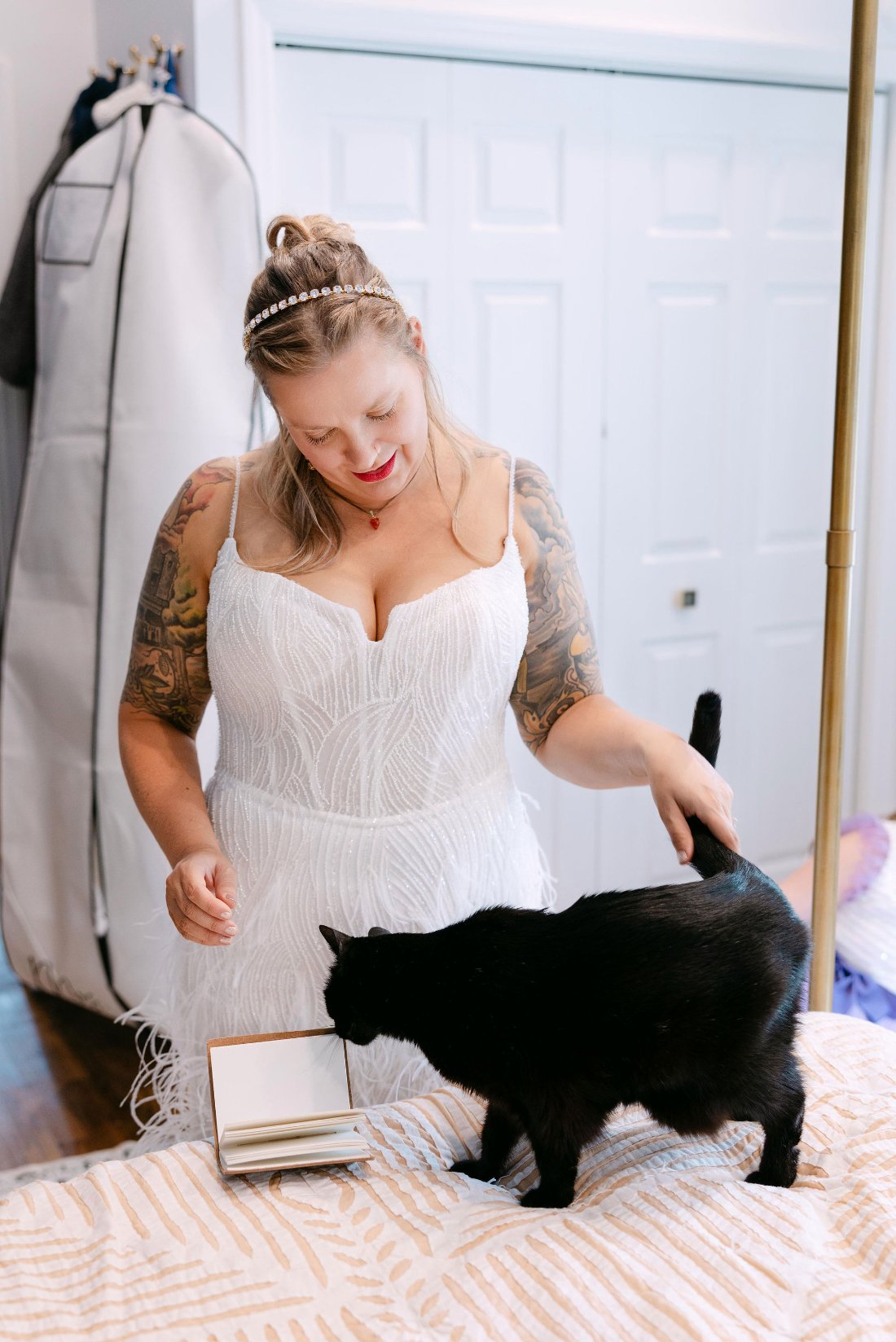 Bride in wedding dress petting her black cat during getting ready moments for outdoor wedding in New York