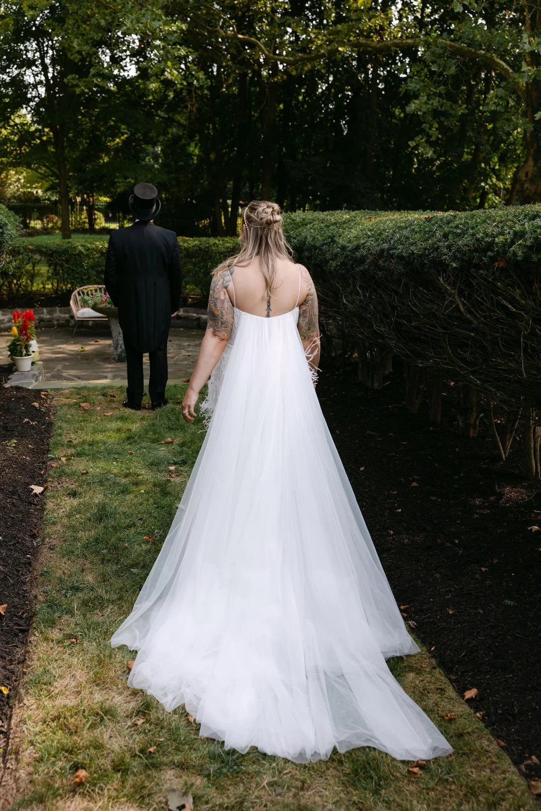 Bride approaching groom for their first look in a garden pathway during their outdoor wedding in New York