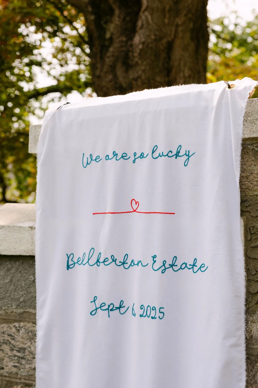 Personalized wedding banner embroidered with venue name and date at outdoor wedding in New York
