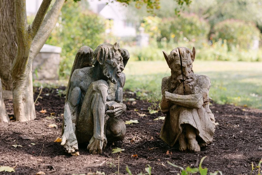 Whimsical stone gargoyle garden statues on private estate grounds during outdoor wedding in New York