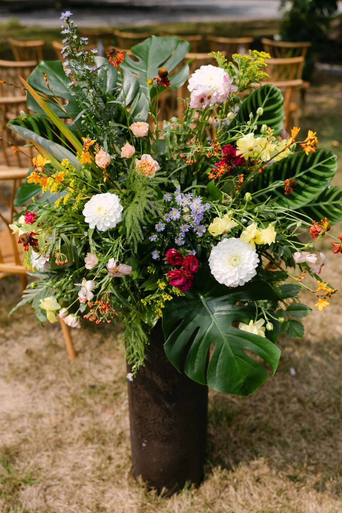 Vibrant tropical-inspired floral arrangement at ceremony aisle for outdoor wedding in New York