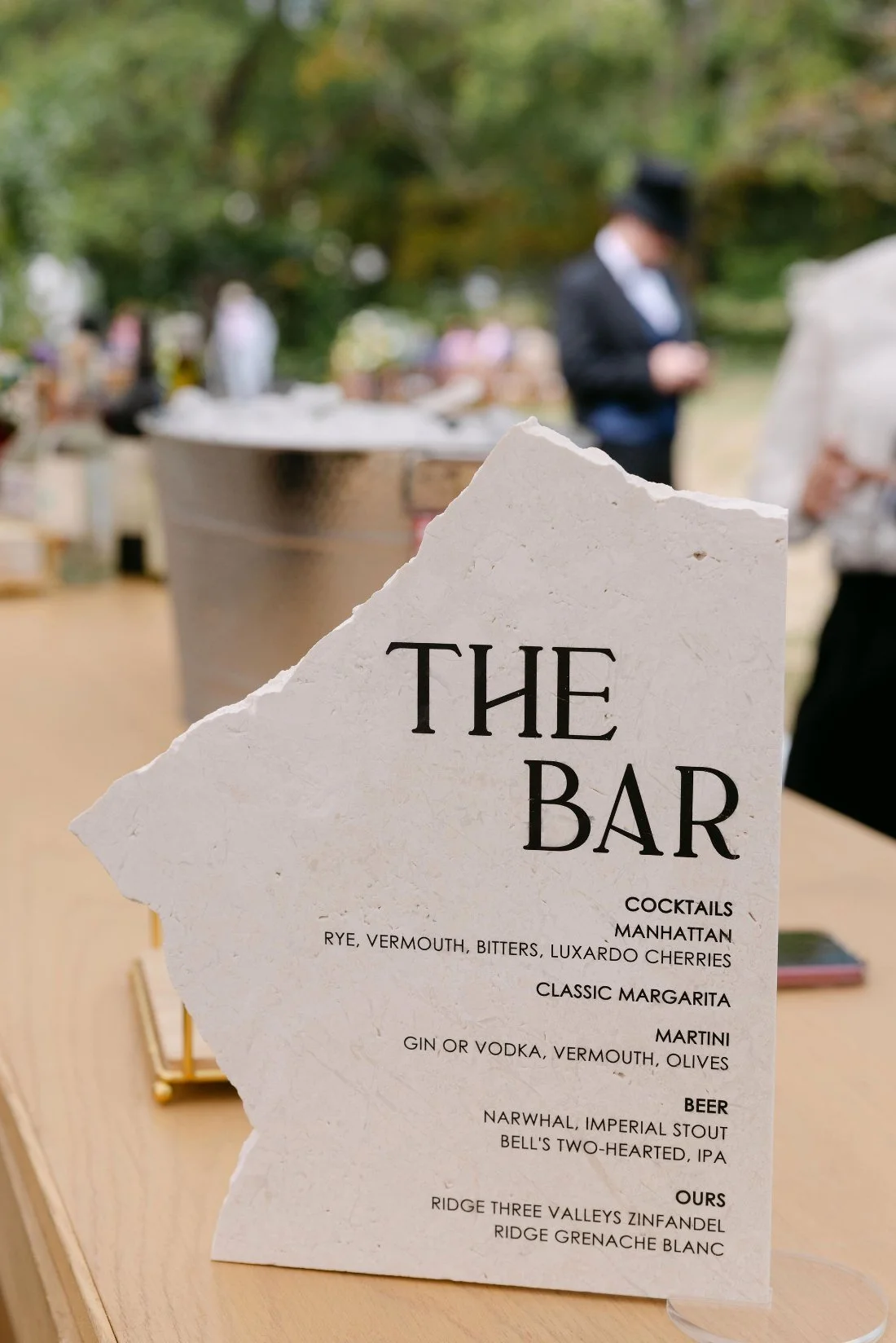 Modern stone drink menu sign with cocktail and wine list at outdoor wedding in New York