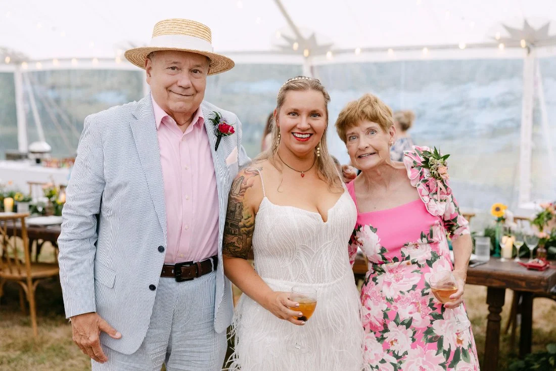 Bride smiling with her parents during the reception at their outdoor wedding in New York