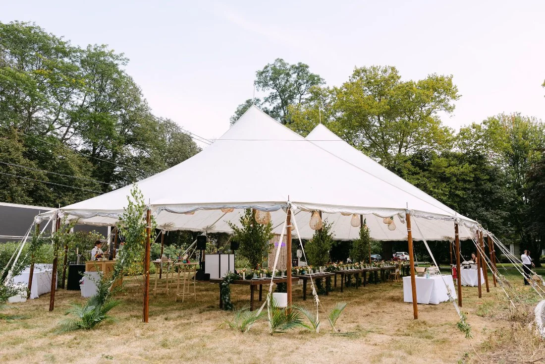 Spacious white tent with glowing lights set up for an outdoor wedding in New York