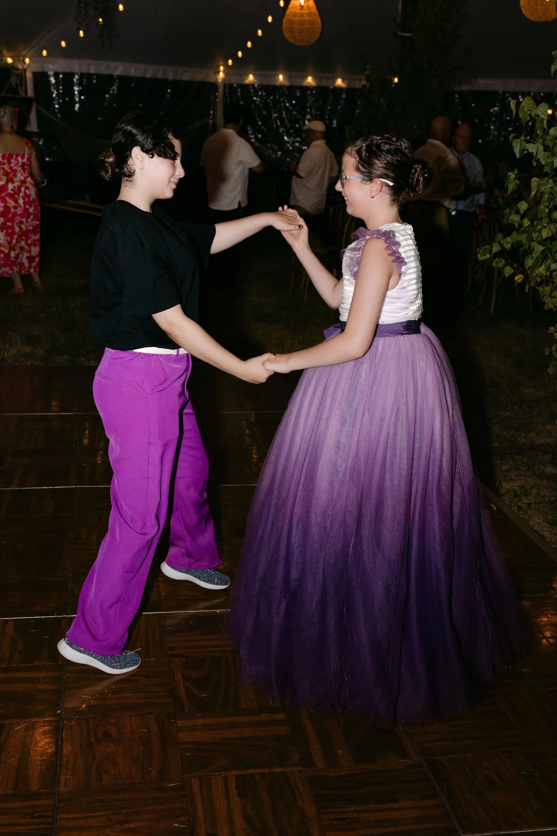 Wedding guests dancing and celebrating under string lights at an outdoor wedding in New York