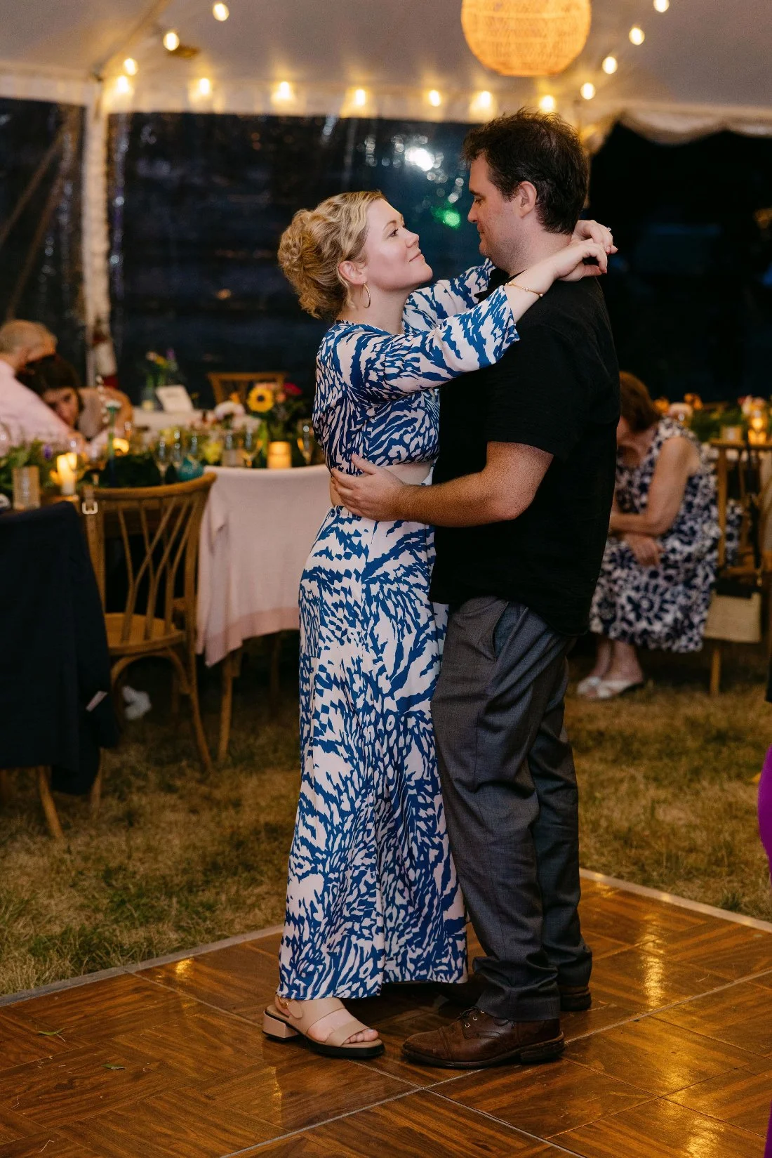 Wedding guests slow dancing together under the tent at an outdoor wedding in New York