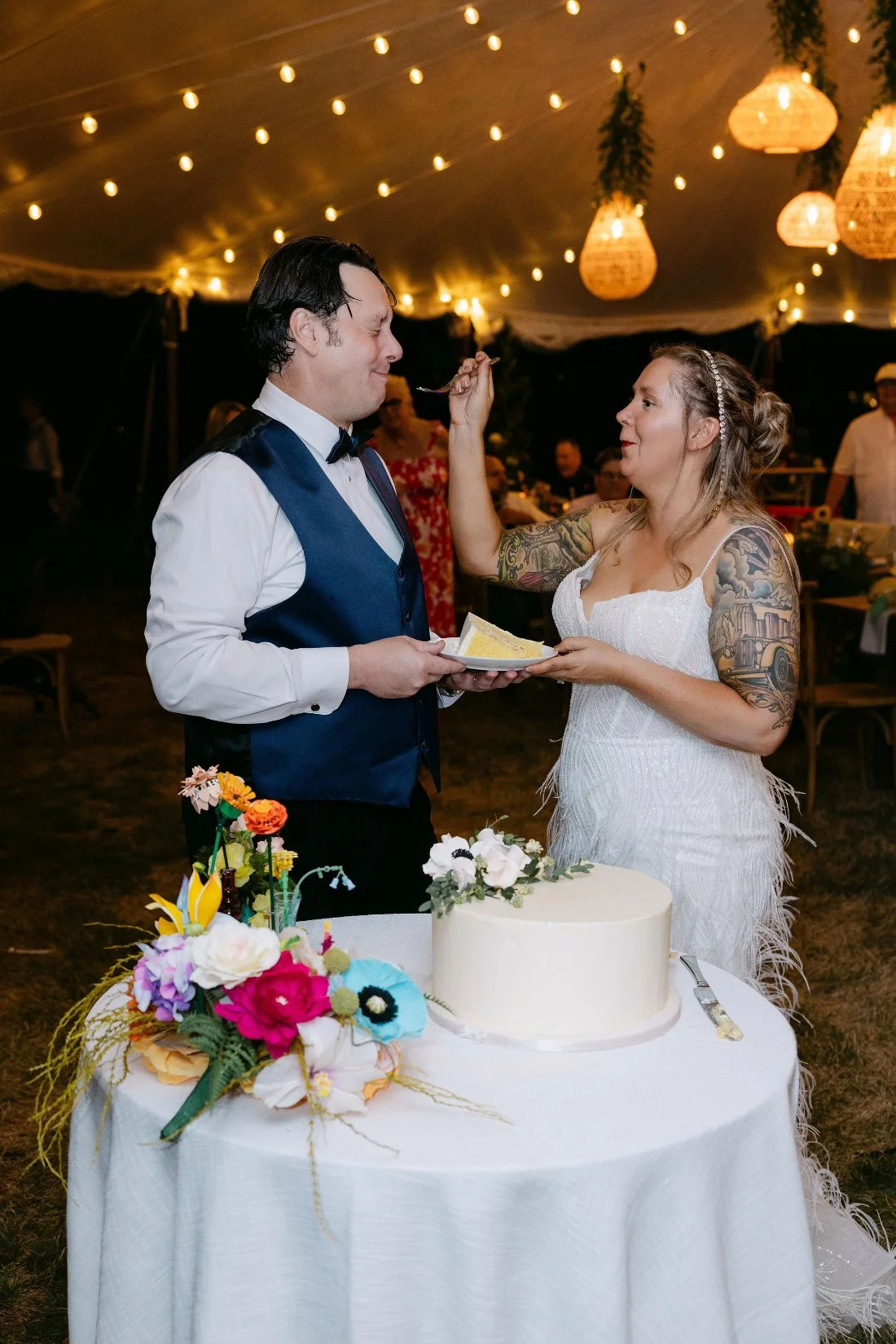 Bride and groom cutting their wedding cake together during their outdoor celebration in New York