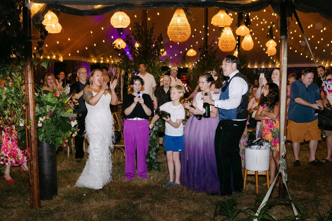 Bride and groom clink glasses during a champagne toast at their outdoor wedding in New York