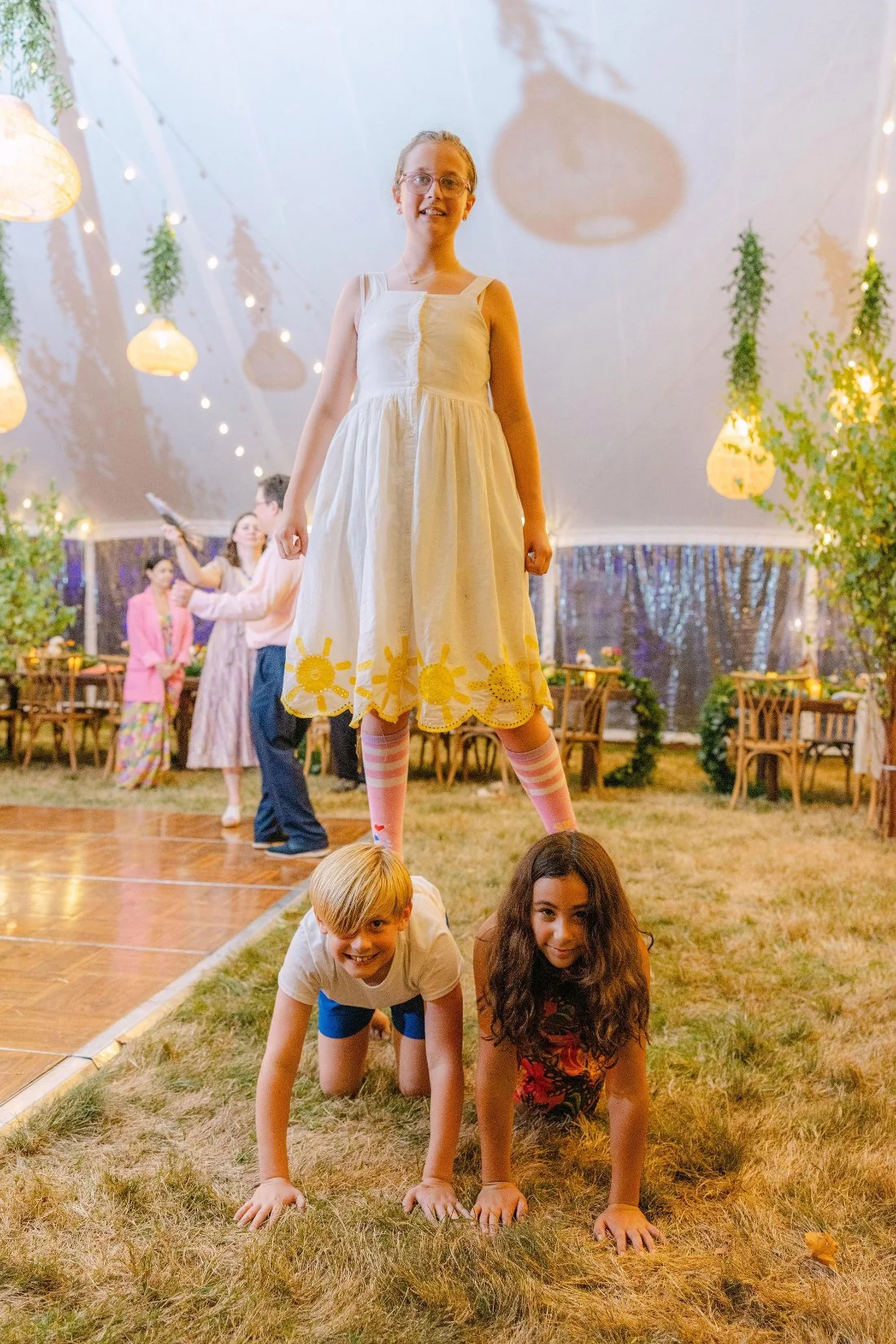Children laughing and playing on the dance floor during an outdoor wedding in New York