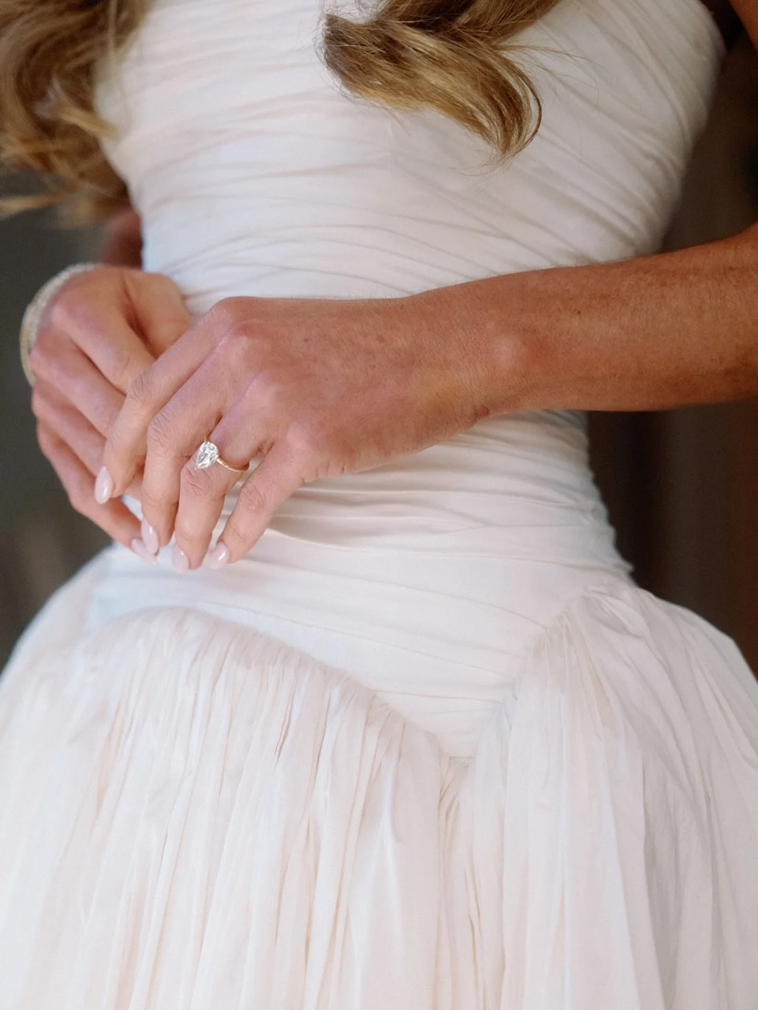 Close-up of the bride’s hands showing her engagement ring and lace gown during her Hamptons wedding morning.