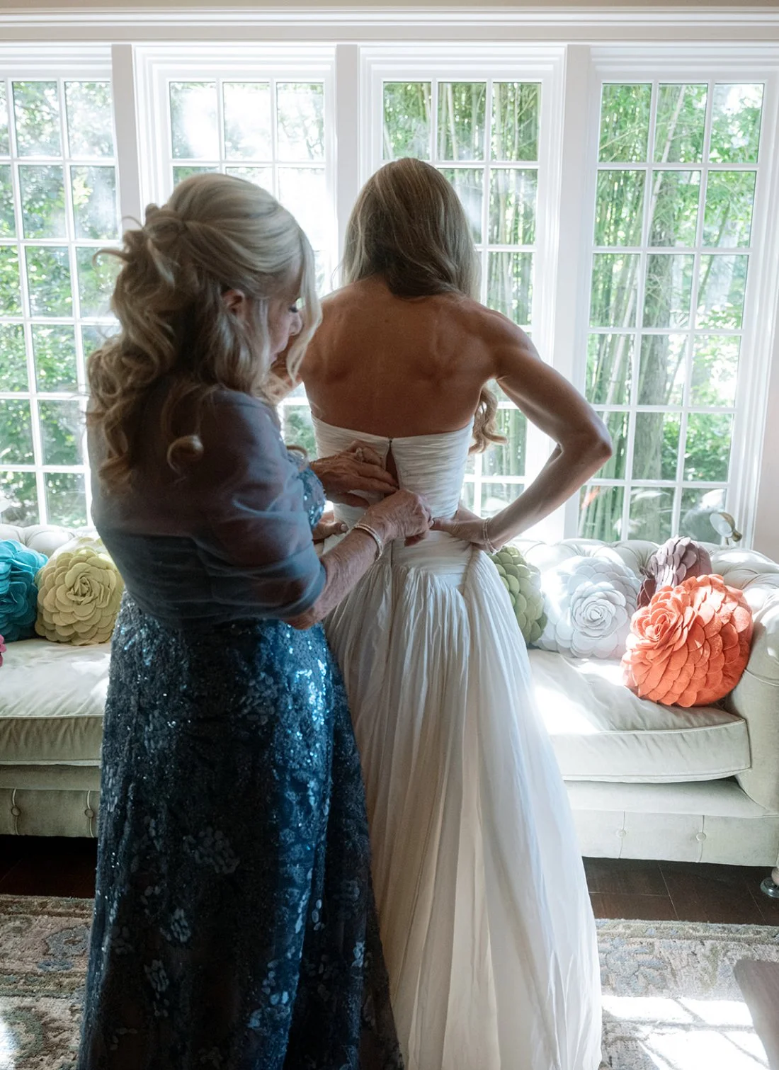 Mother of the bride helping her into her wedding dress before the Hamptons wedding ceremony.
