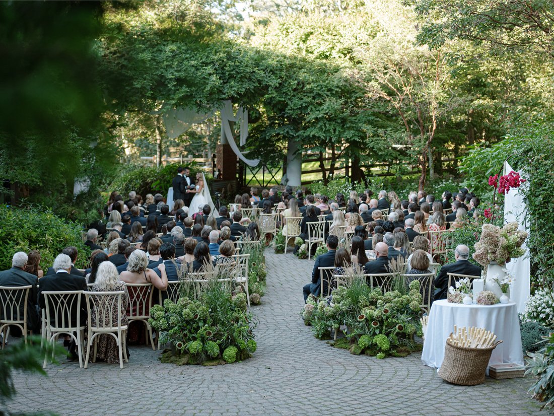 Wide view of the outdoor ceremony taking place at a Hamptons wedding in Water Mill.