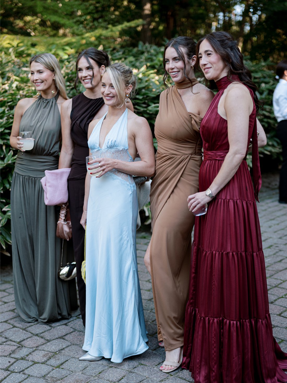 Friends gathered together watching and mingling at cocktail hour outside the private residence.