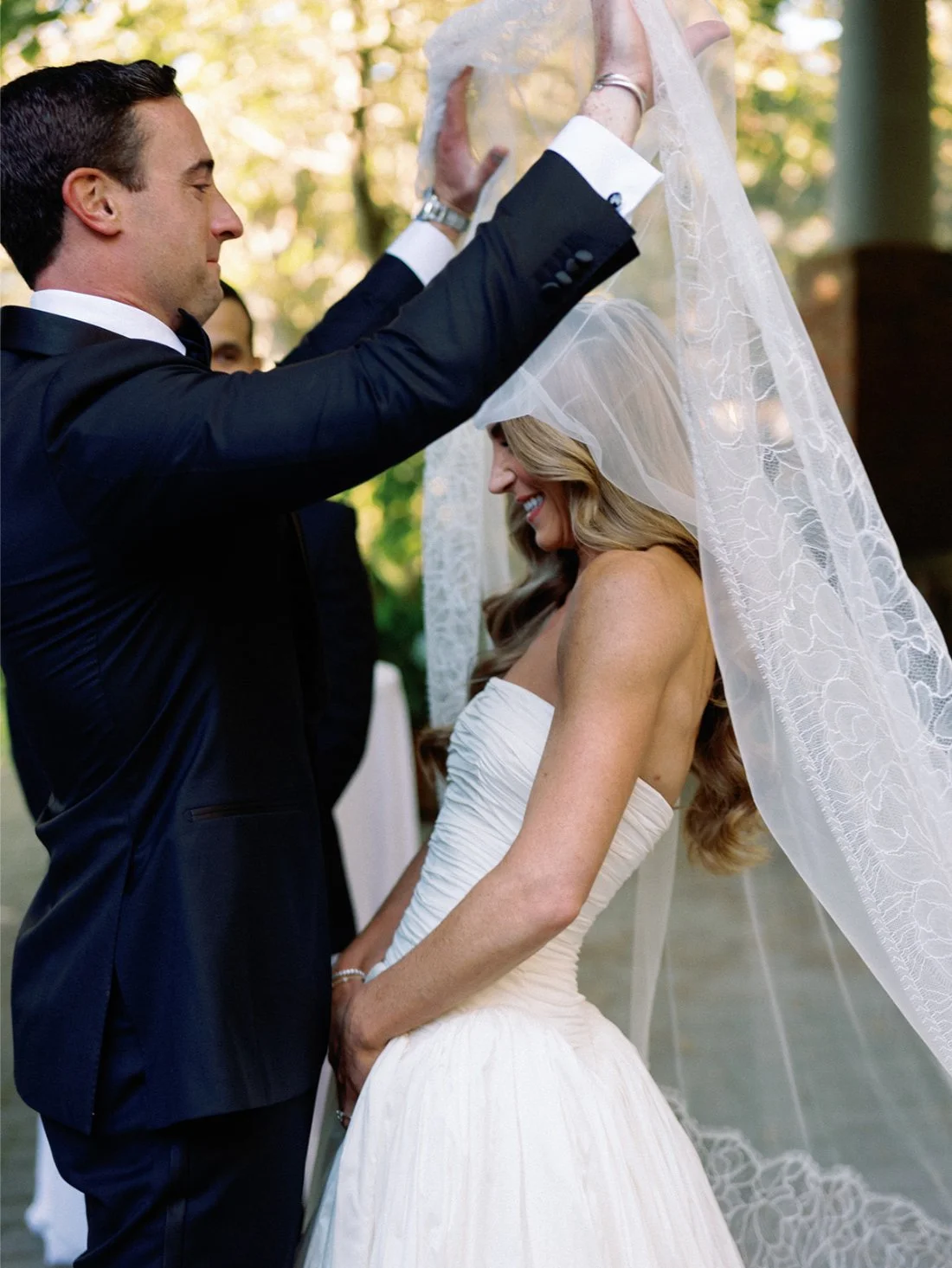 Groom lifting the bride’s veil at the altar during their Hamptons wedding ceremony.