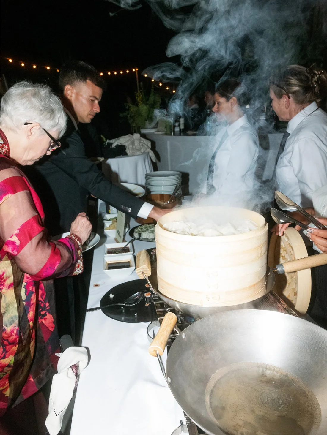 Catering staff serving dinner to guests at an outdoor private estate wedding in Water Mill.