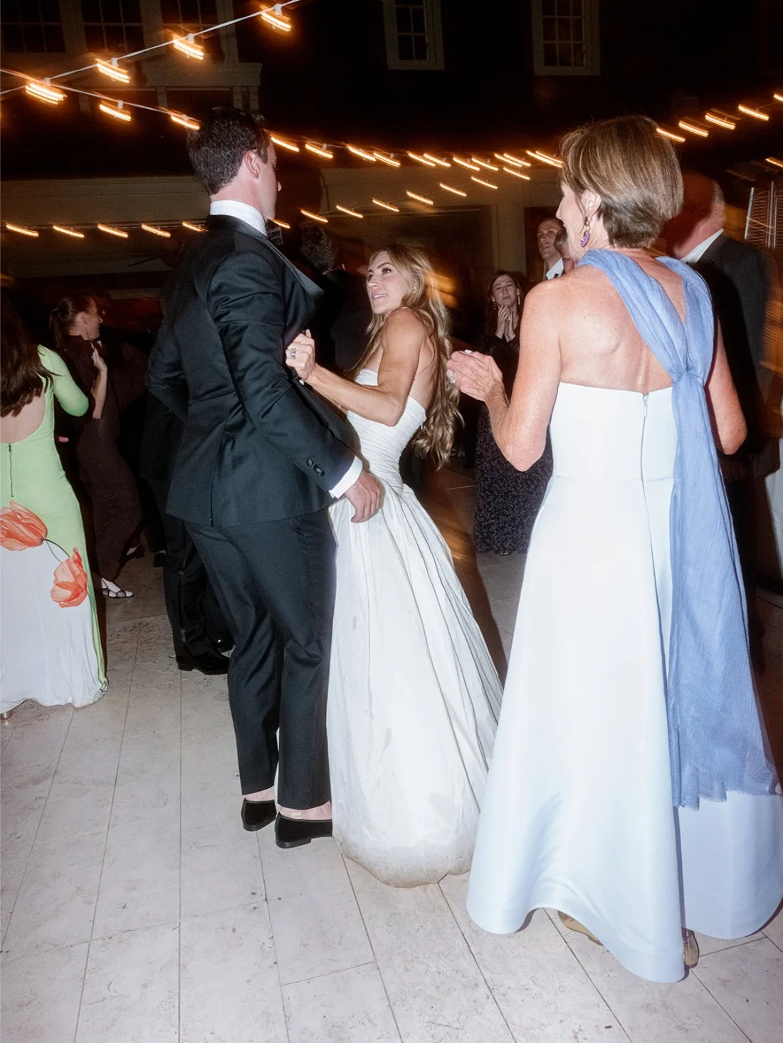 Bride and groom dancing together surrounded by friends and family at their Hamptons wedding.