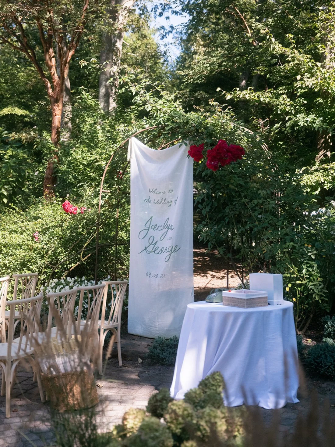Welcome sign displayed at the entrance of a Hamptons wedding in Water Mill surrounded by lush greenery and garden florals.