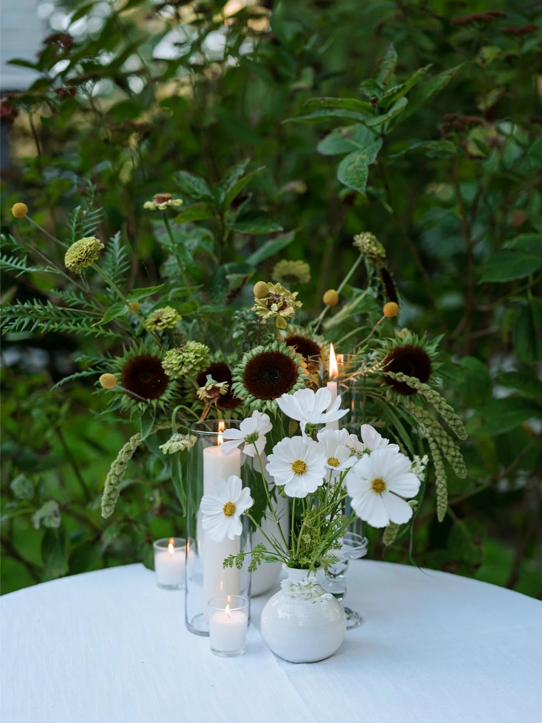 Moody floral arrangement featuring white cosmos and dark-centered blooms at a Hamptons wedding reception.