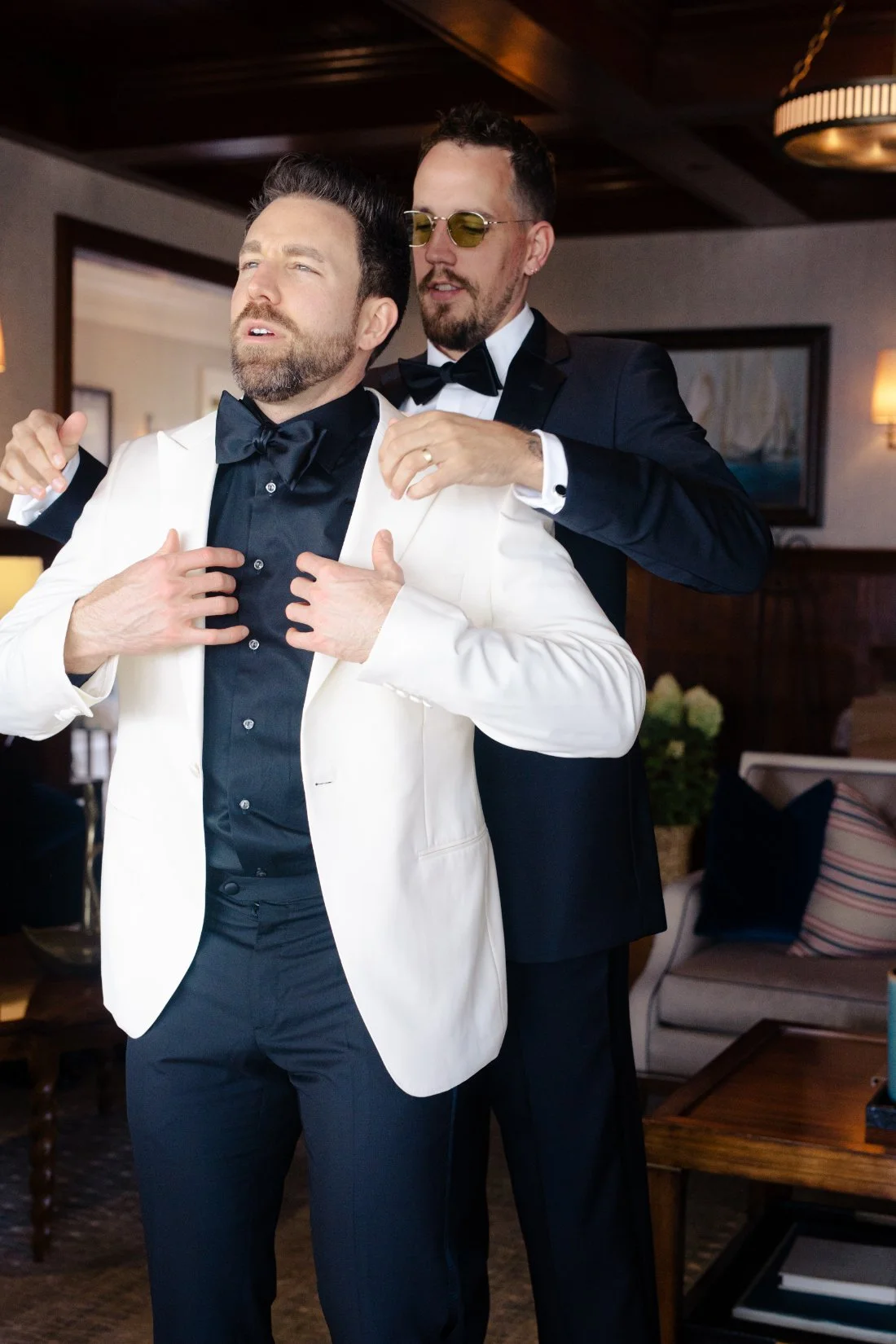 Groom adjusting jacket with groomsman during Peconic Bay Yacht Club wedding morning