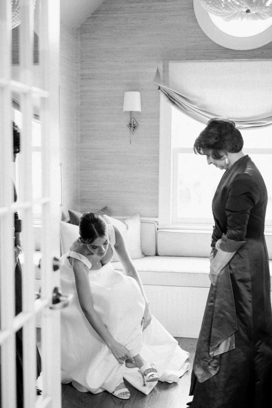 Bride adjusting wedding shoes in getting ready suite at Peconic Bay Yacht Club