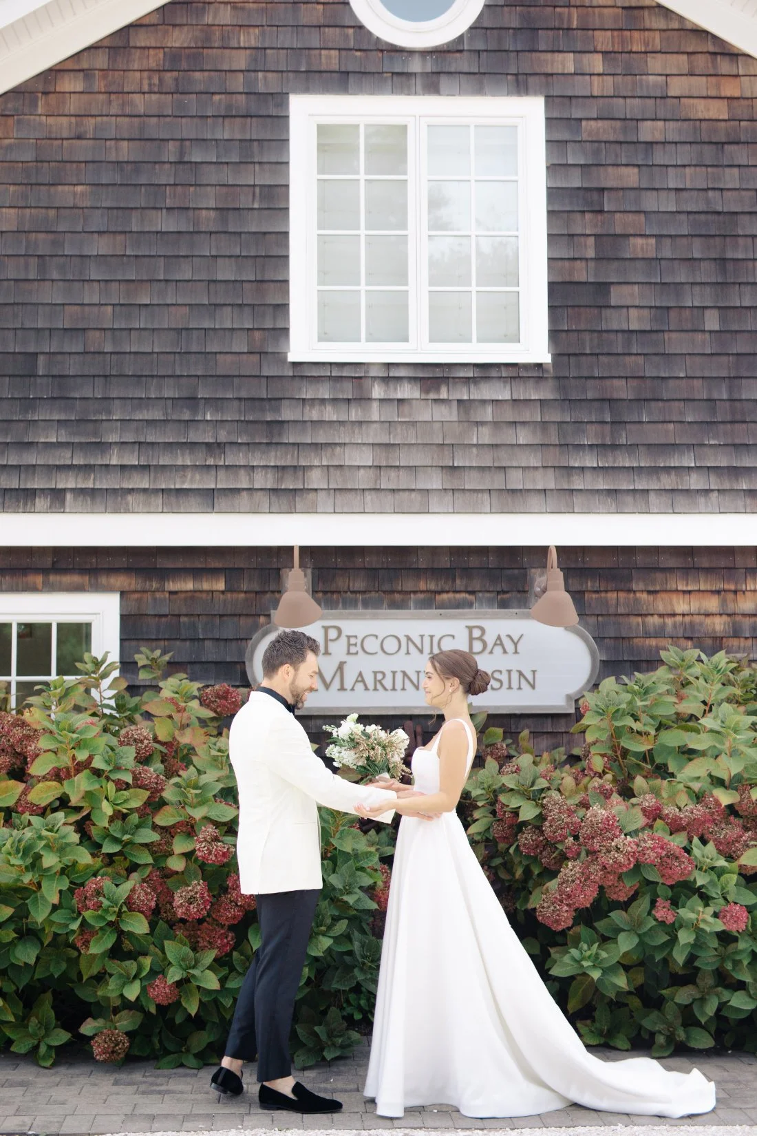 Bride and groom holding hands during first look at Peconic Bay Yacht Club