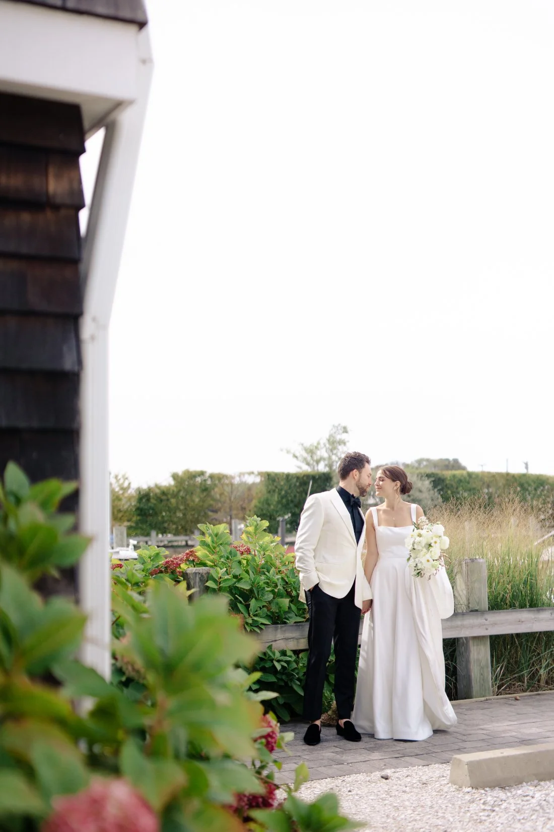 Bride and groom holding hands near waterfront at Peconic Bay Yacht Club