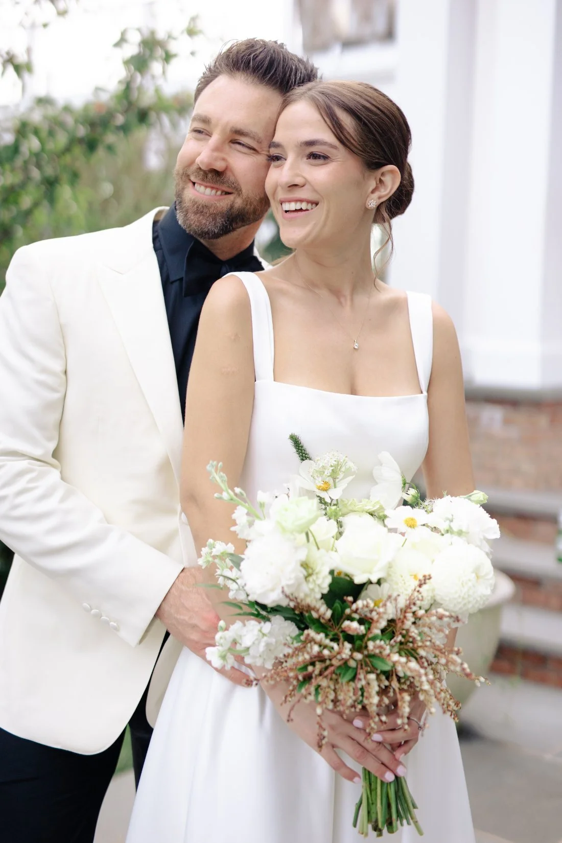 Close-up of bride smiling with bouquet and groom at Peconic Bay Yacht Club