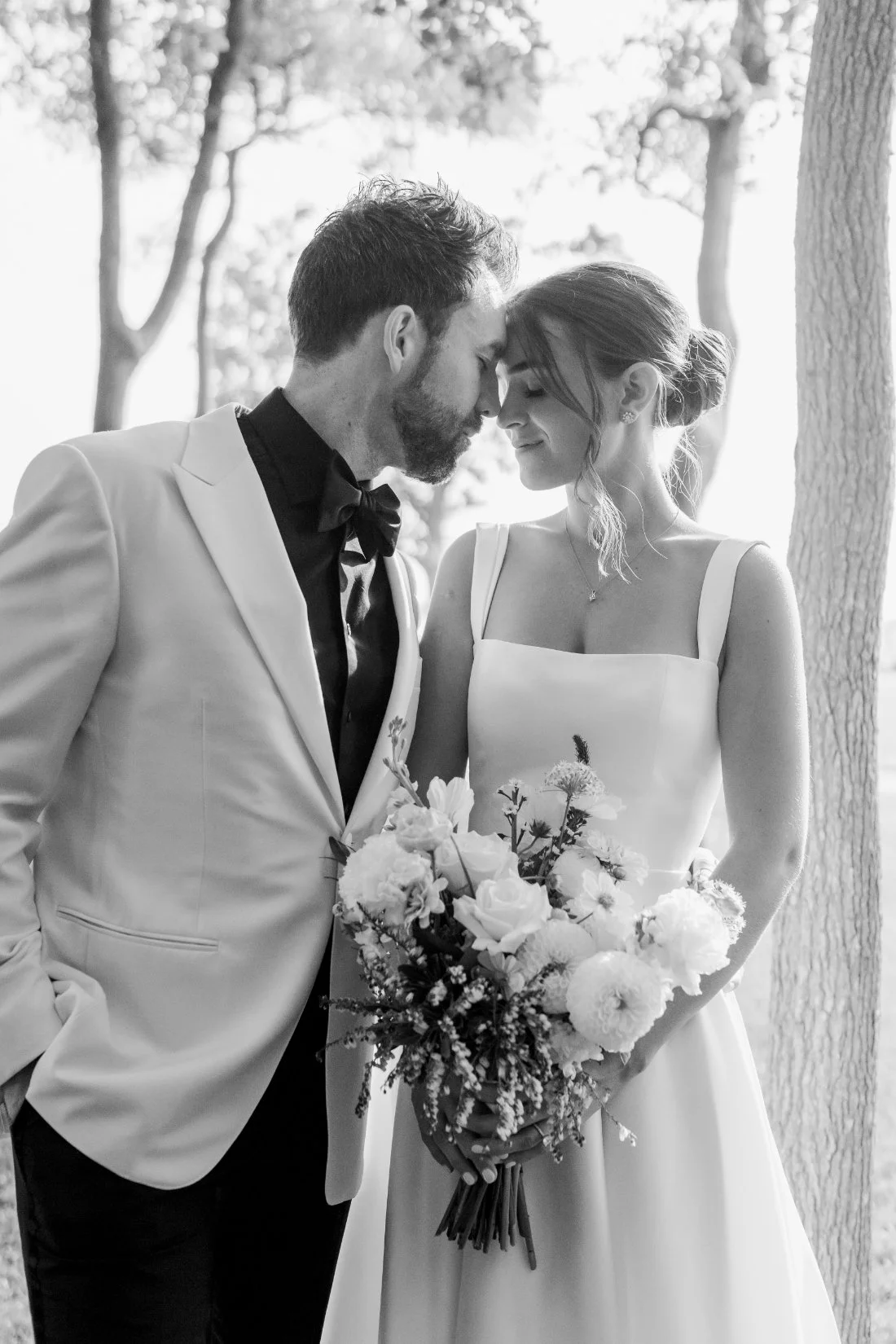 Candid black and white moment of bride and groom with bouquet at Peconic Bay Yacht Club