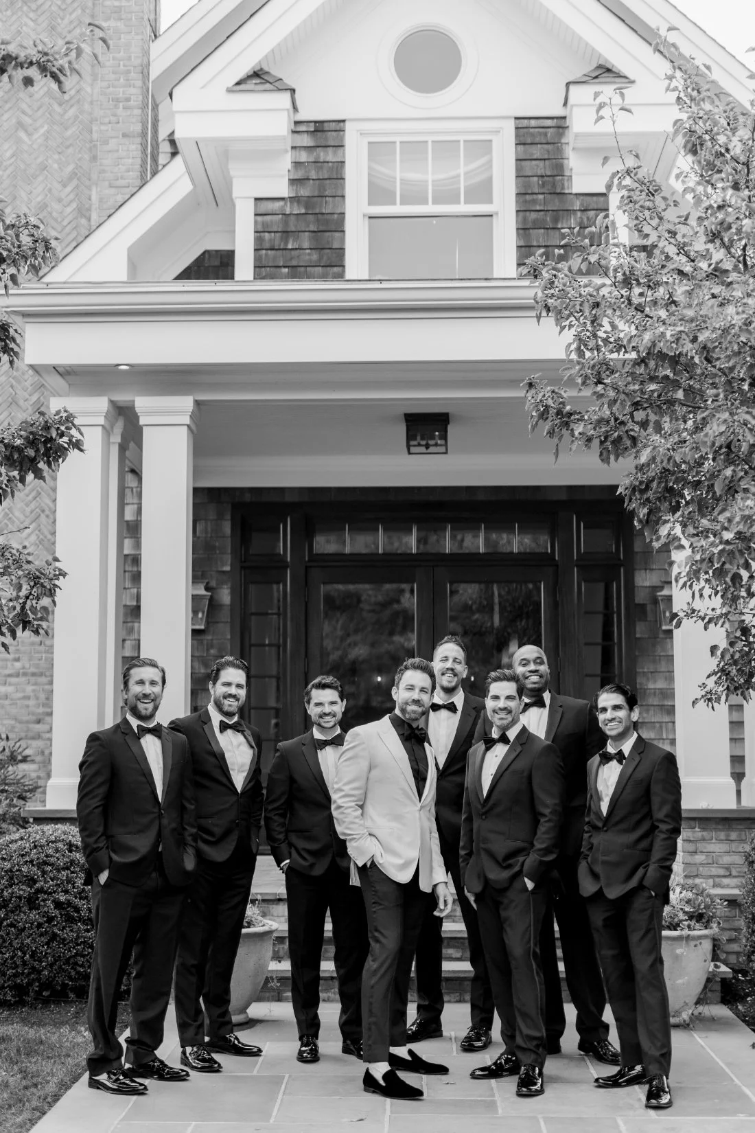 Black and white portrait of groomsmen in tuxedos outside Peconic Bay Yacht Club