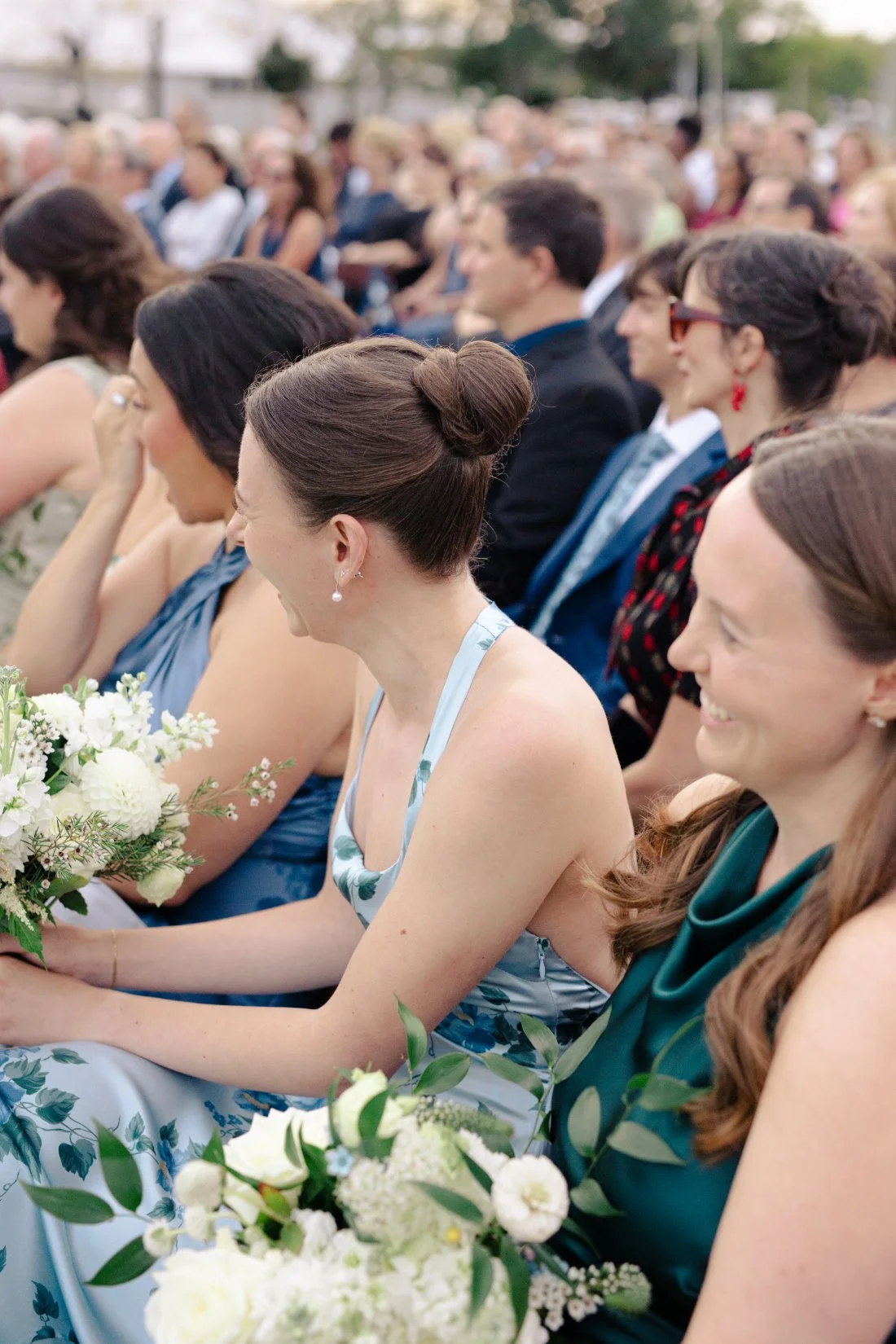 Wedding guests seated and smiling during outdoor ceremony at Peconic Bay Yacht Club