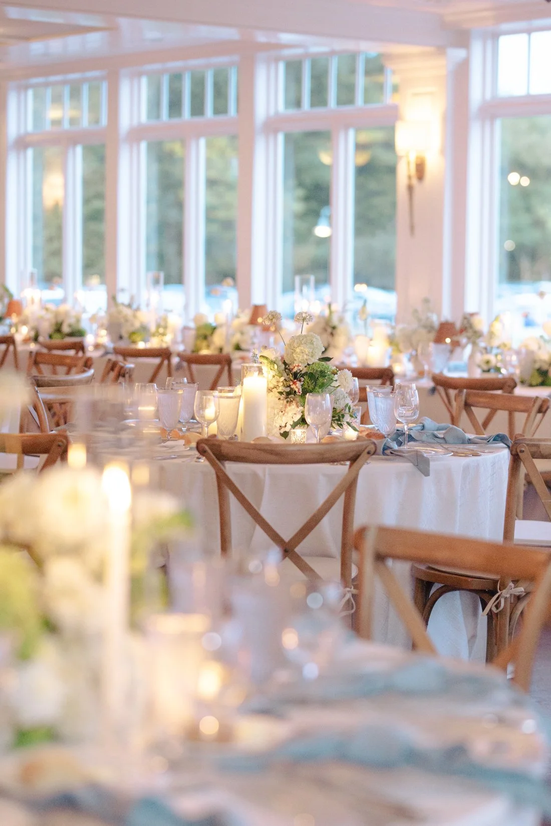 Reception tables glowing with candlelight and greenery at Peconic Bay Yacht Club