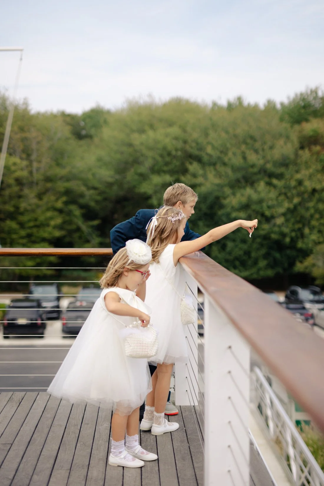 Flower girls and ring bearer leaning over railing during Peconic Bay Yacht Club reception