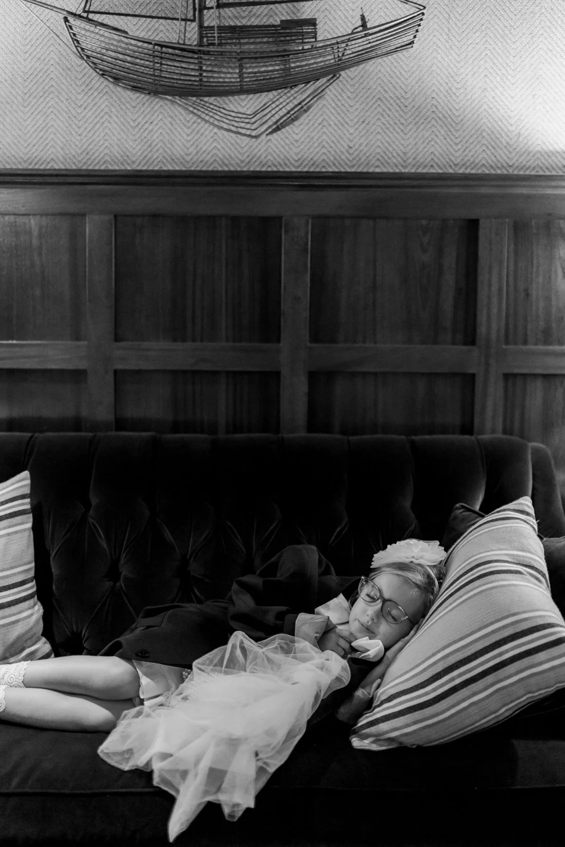 Flower girl asleep on couch during wedding reception at Peconic Bay Yacht Club